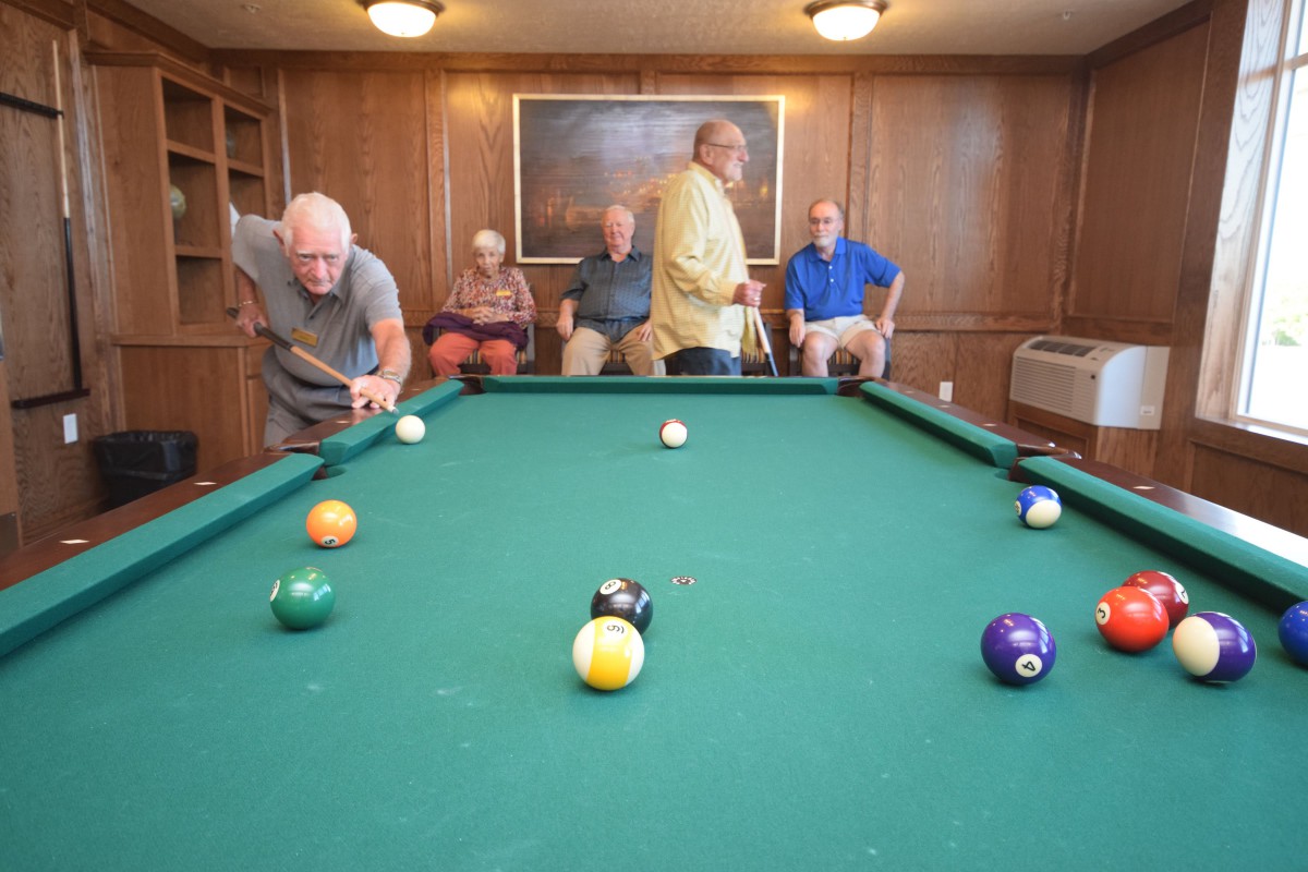 A group of men enjoying a game of billiards in a cozy game room.