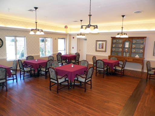 A spacious dining area with maroon tablecloths and comfortable seating, ideal for gatherings.