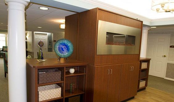 A modern office interior featuring wooden cabinets and shelves with decorative items.