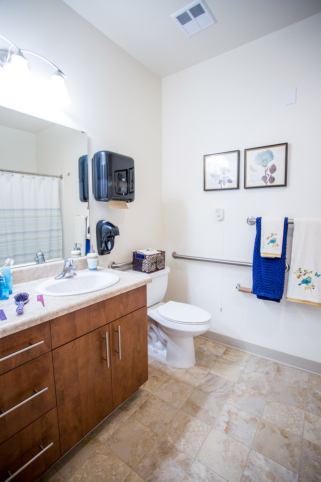 A clean and organized bathroom with a sink, toilet, and towels.