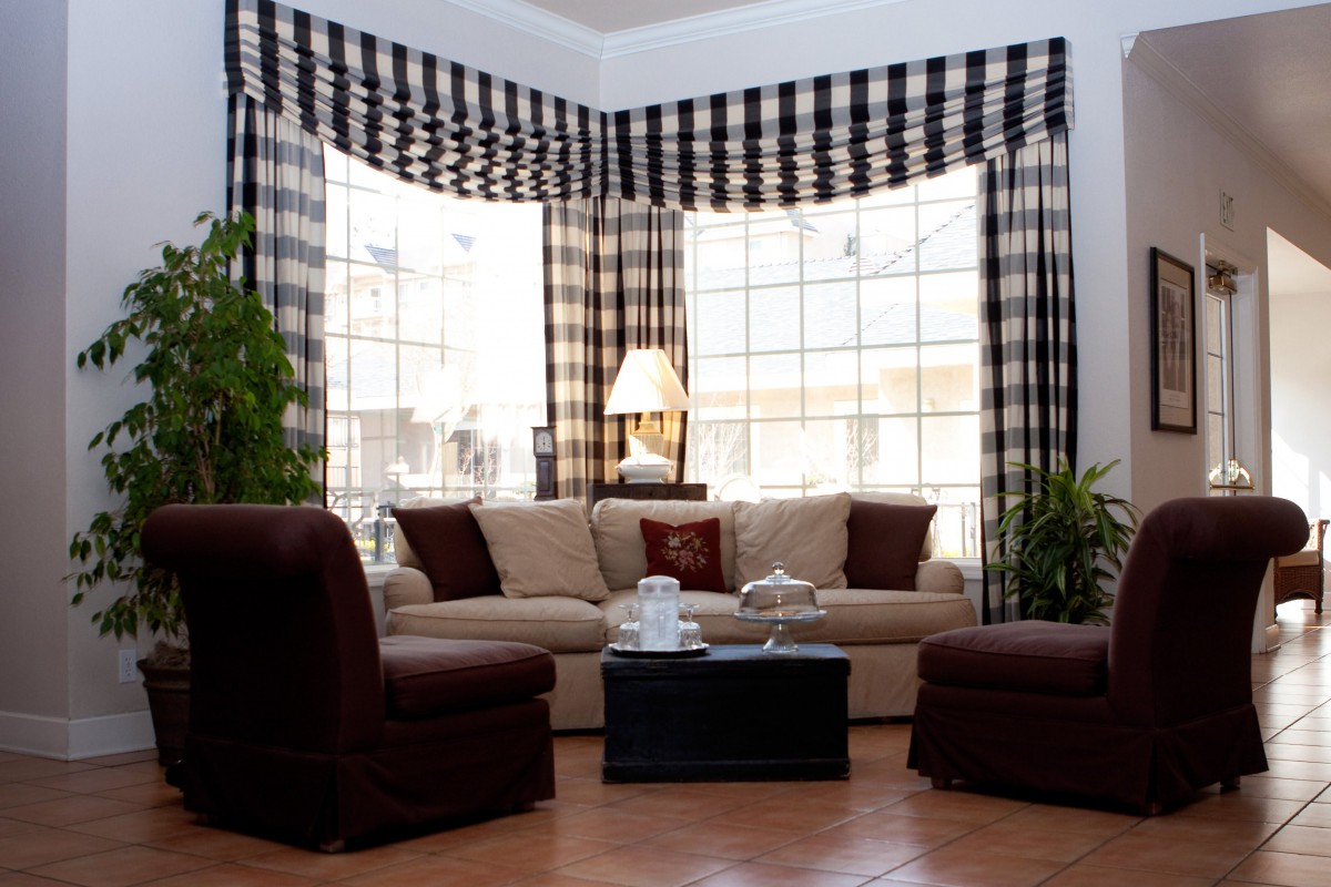 A cozy living room with a beige sofa, checkered curtains, and a coffee table.