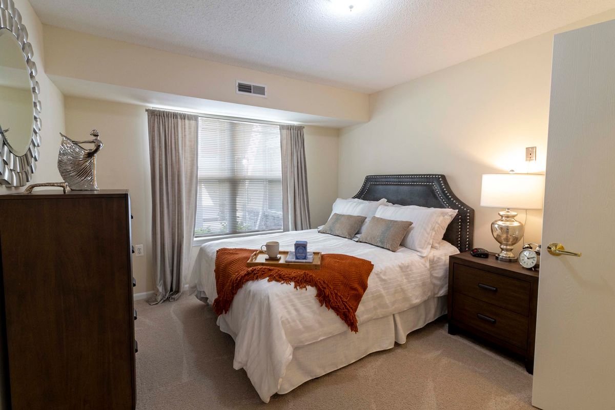 A cozy bedroom with a neatly made bed, soft lighting, and elegant decor.