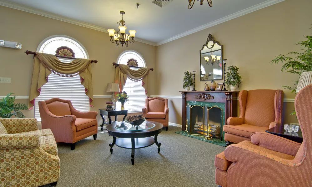 A traditional living room with comfortable armchairs and an ornate fireplace.