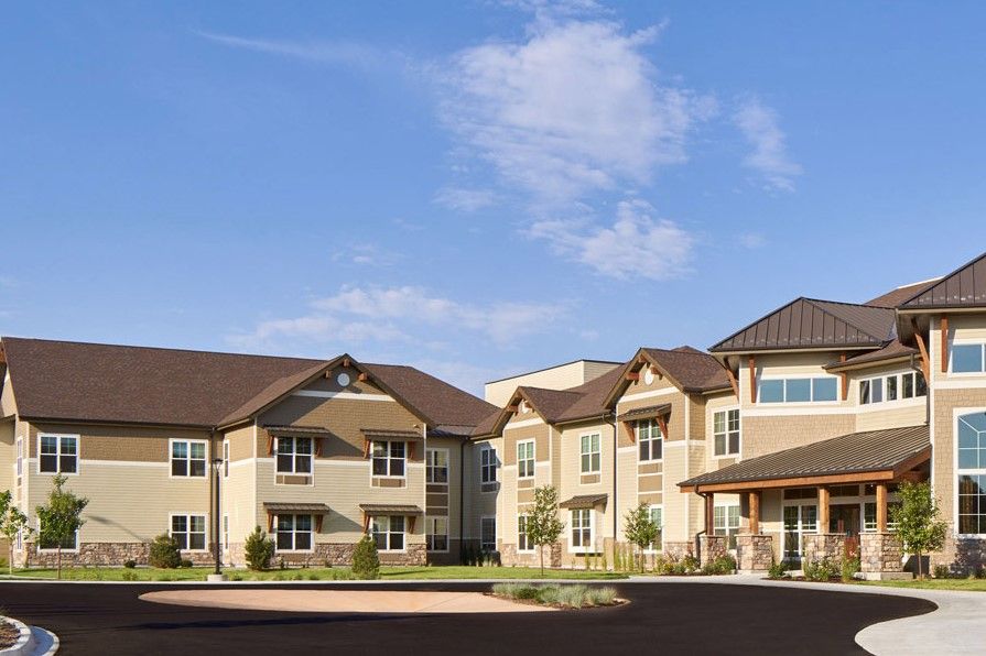 A modern residential apartment complex under a clear blue sky.
