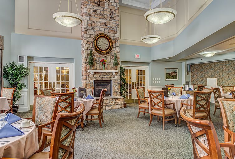 A cozy dining room with a stone fireplace and elegant furniture arrangement.