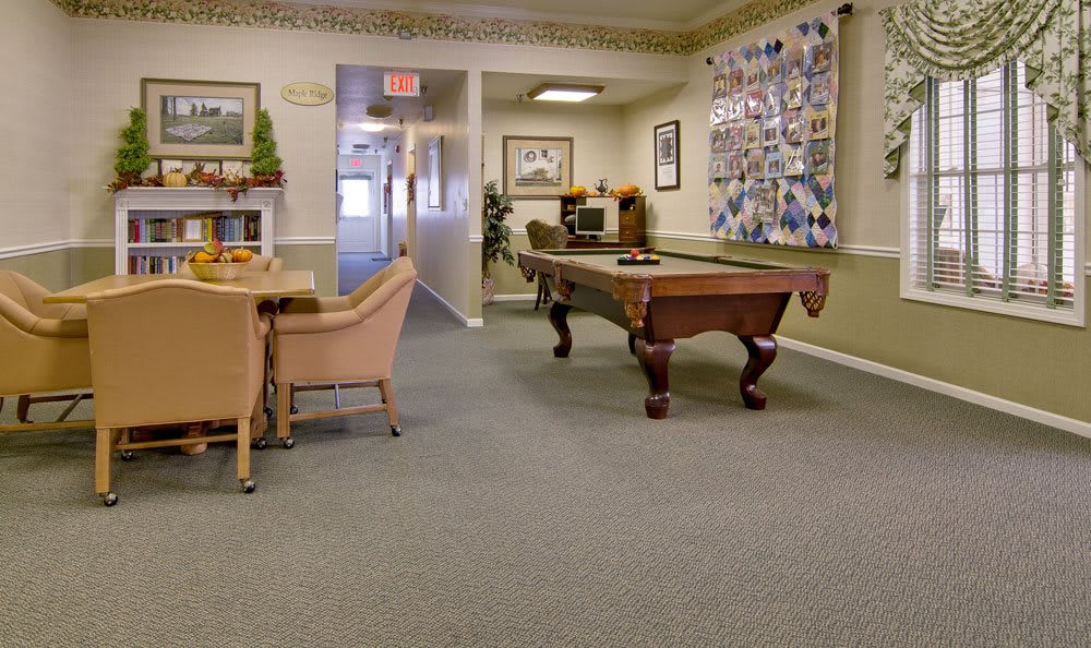 A recreational room featuring a pool table and comfortable seating.