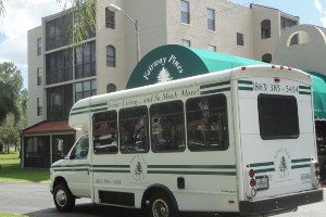 A shuttle bus parked on a city street in front of a building.