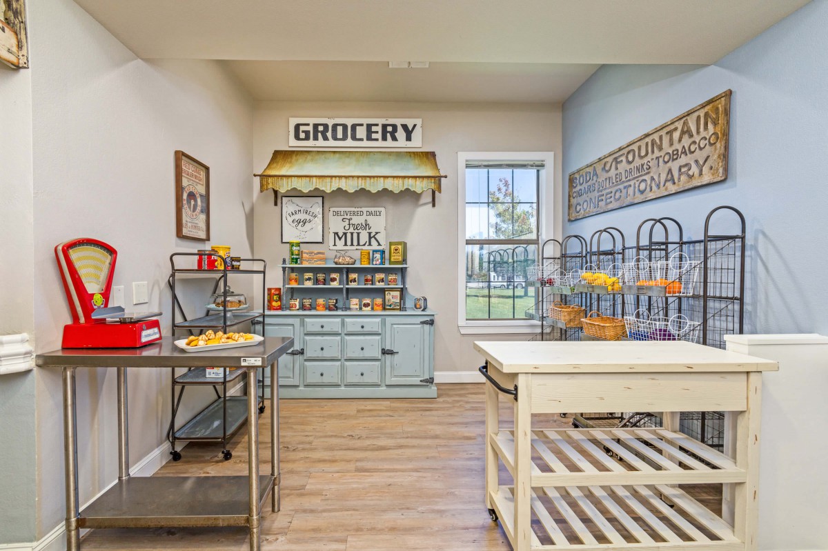 A children's playroom designed to resemble a small grocery store, complete with shelves, toy food items, and playful decor.