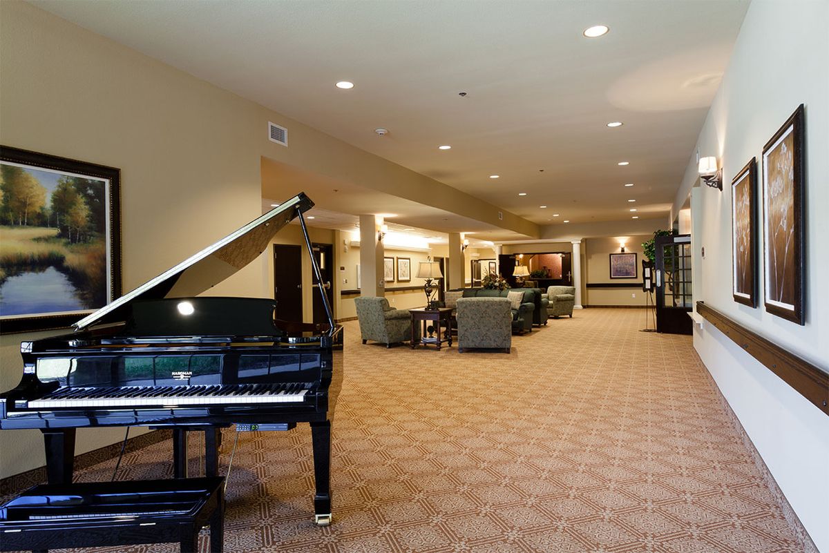 A spacious lobby interior with a grand piano and seating area.
