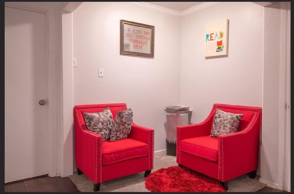 A cozy living room corner featuring two bright red chairs and modern decor.