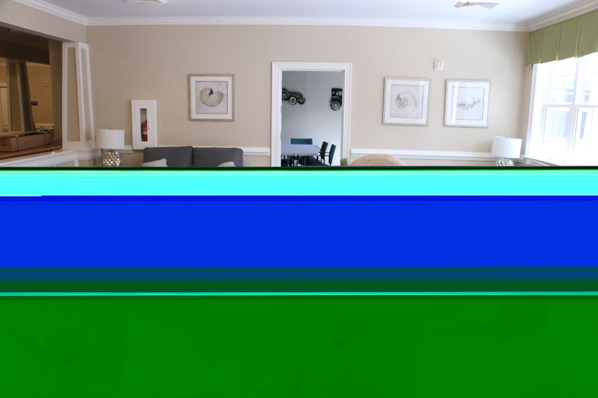 A living room interior with artwork displayed on the walls.