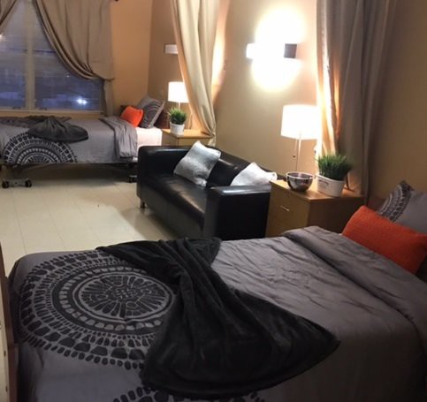 A cozy bedroom with two beds, a sofa, and stylish decor.