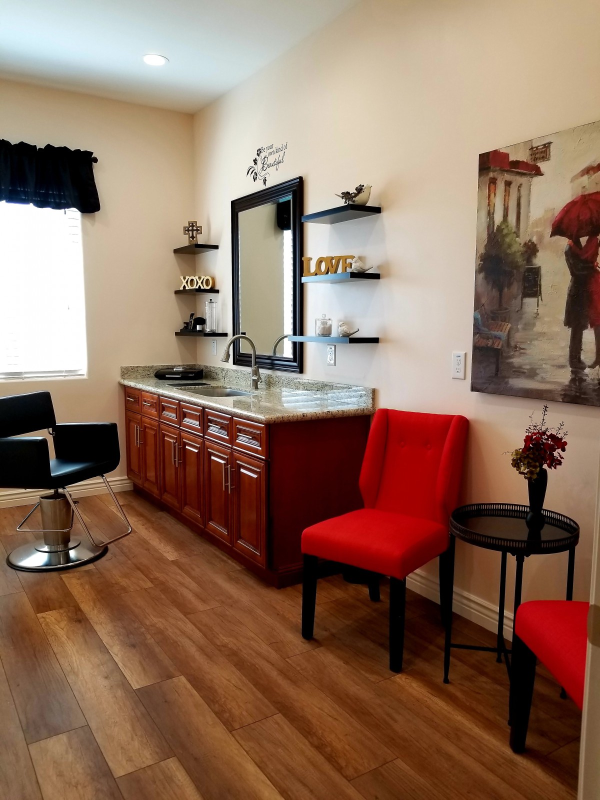 A well-decorated hair salon interior with a styling station and vibrant red chairs.