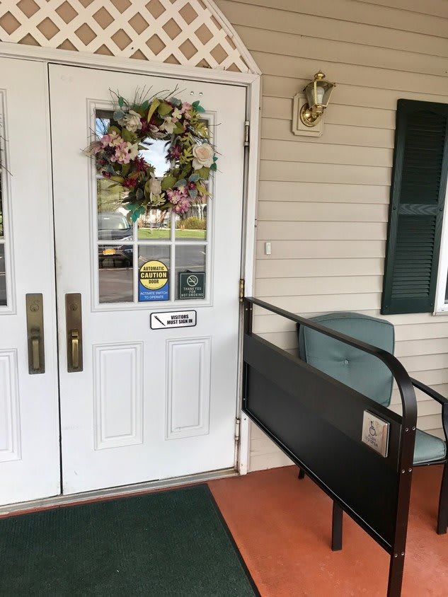 An entrance with a decorative wreath and a wheelchair ramp.