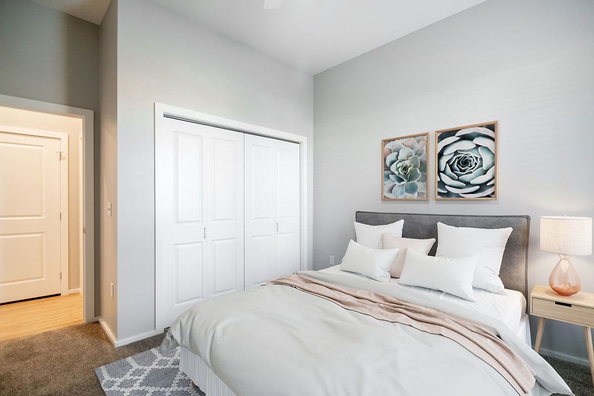 A modern bedroom with a comfortable bed, decorative pillows, and artwork on the wall.