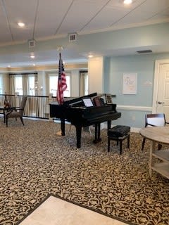 A cozy room featuring a grand piano and an American flag.