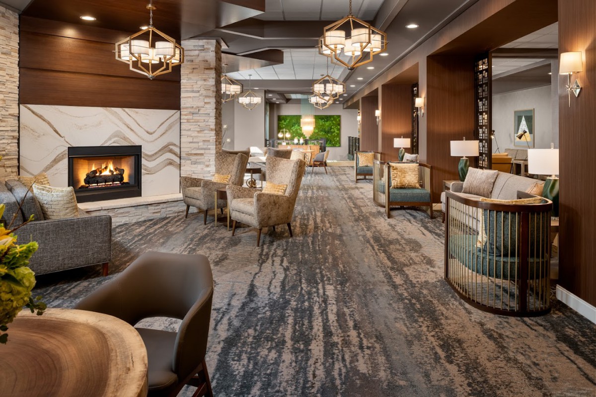 A modern, elegant lounge with a cozy fireplace and comfortable seating arrangement.