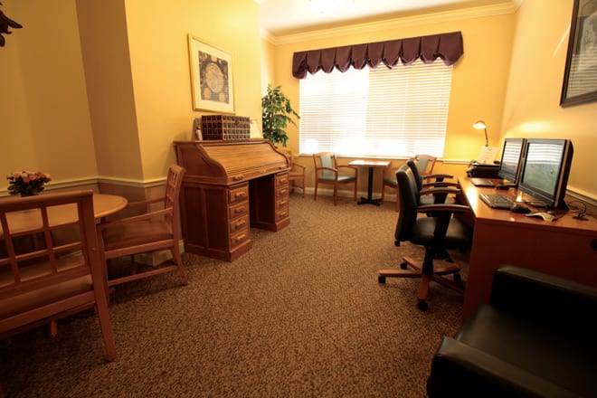 A cozy office space with wooden furniture and ample natural light.