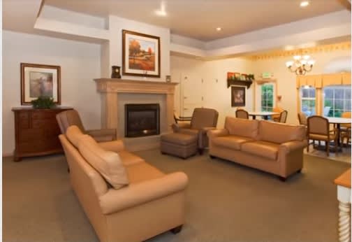 A cozy living room featuring comfortable sofas, a fireplace, and elegant artwork.