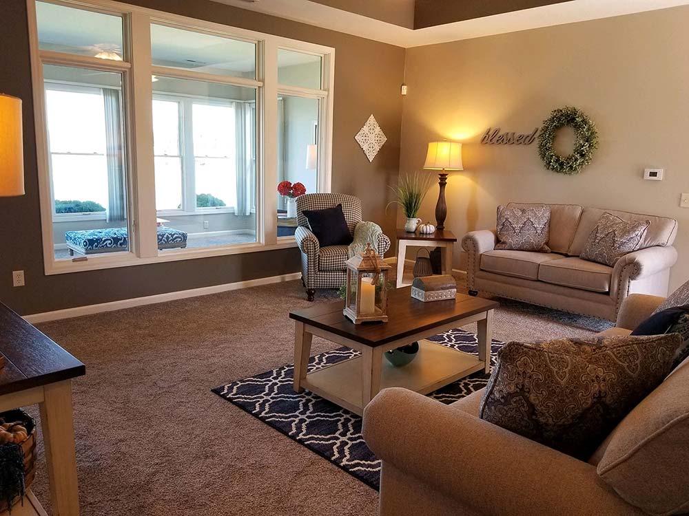 A cozy living room with a sofa, coffee table, and large windows.
