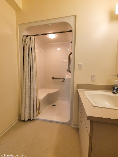 A well-lit bathroom featuring a shower, bathtub, and sink.