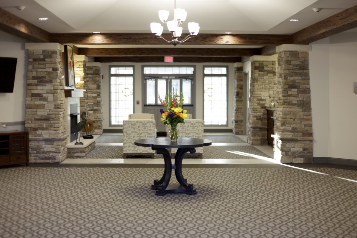 A well-decorated lobby featuring stone walls and a central table with a floral arrangement.