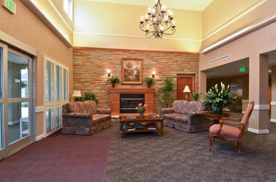 A cozy living room with a fireplace, decorated with sofas and a chandelier.