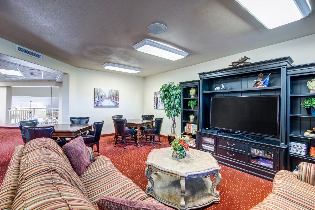 A cozy living room with a sofa, large television, and decorative elements.