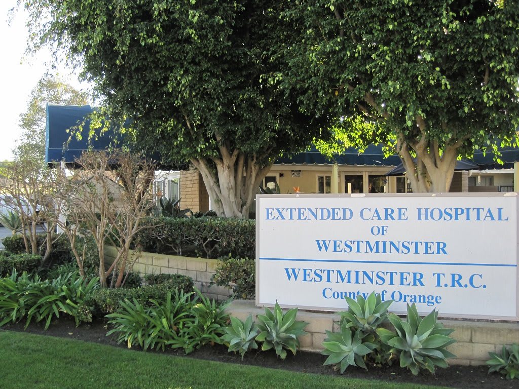 Entrance sign for Extended Care Hospital of Westminster surrounded by trees and landscaping.