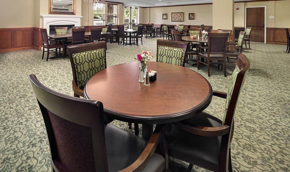 An empty dining area with neatly arranged wooden tables and chairs, ready for guests.