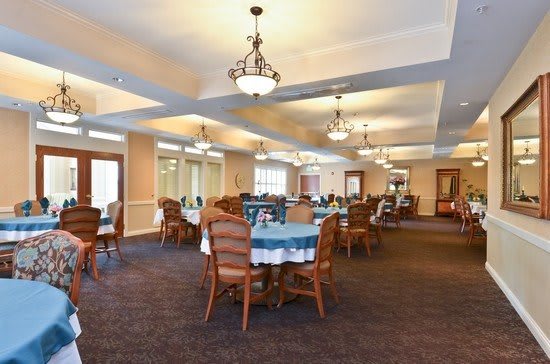 A well-lit dining area with neatly arranged tables and chairs.
