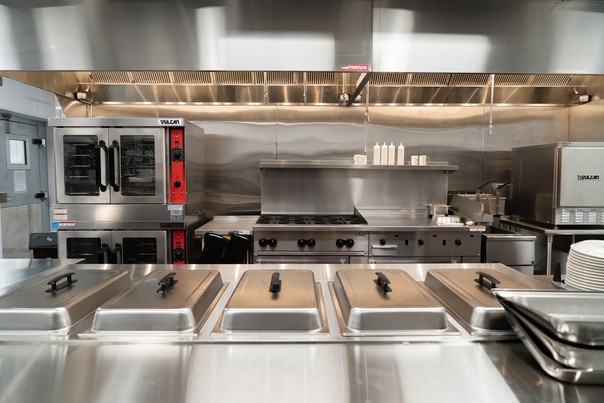A clean and well-organized commercial kitchen with stainless steel appliances and cooking equipment.