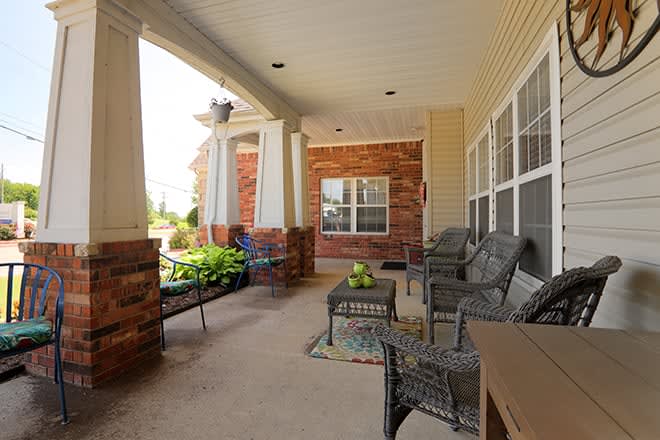 Cozy outdoor porch with comfortable seating and decor.