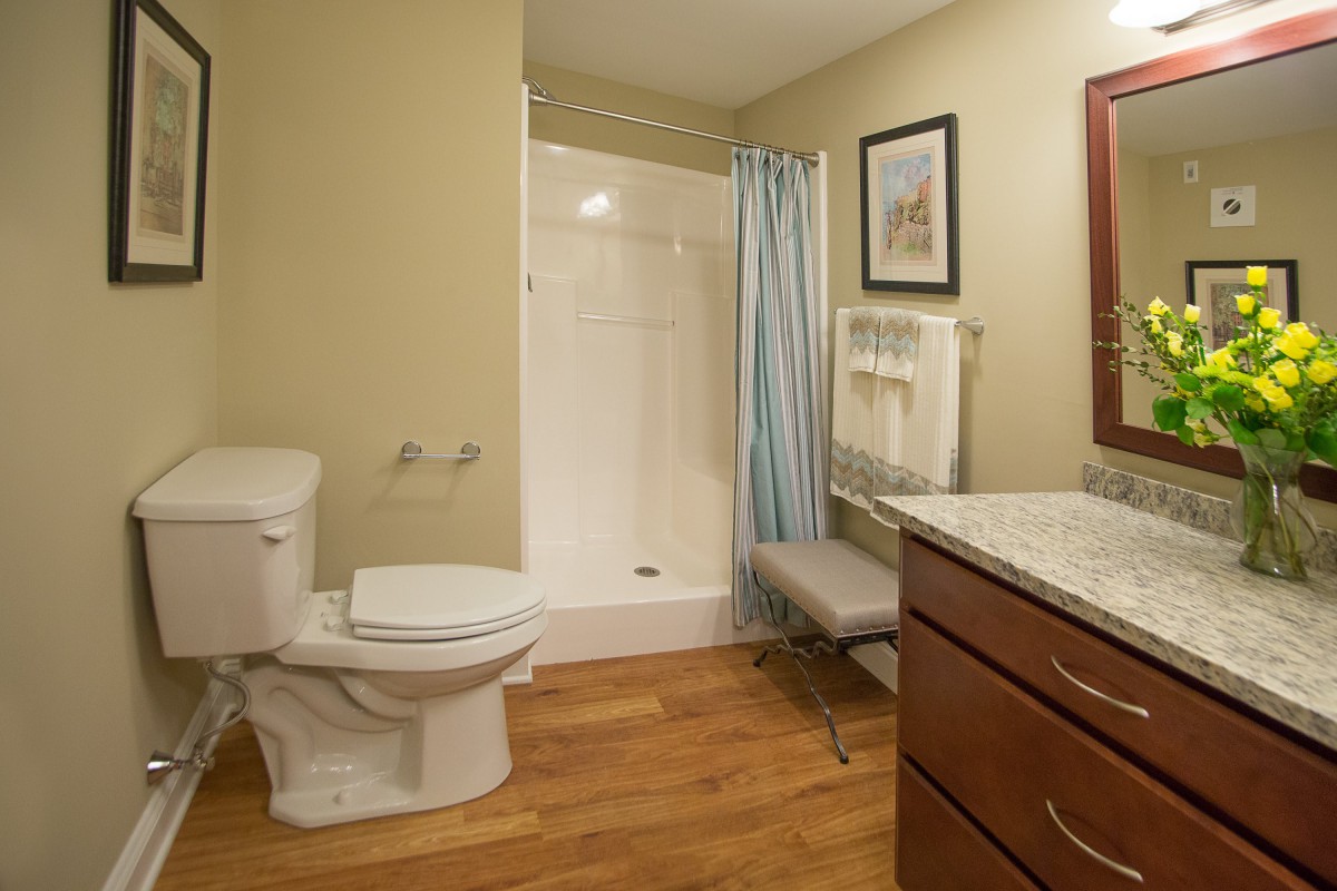 A clean and modern bathroom with a shower, toilet, and sink.