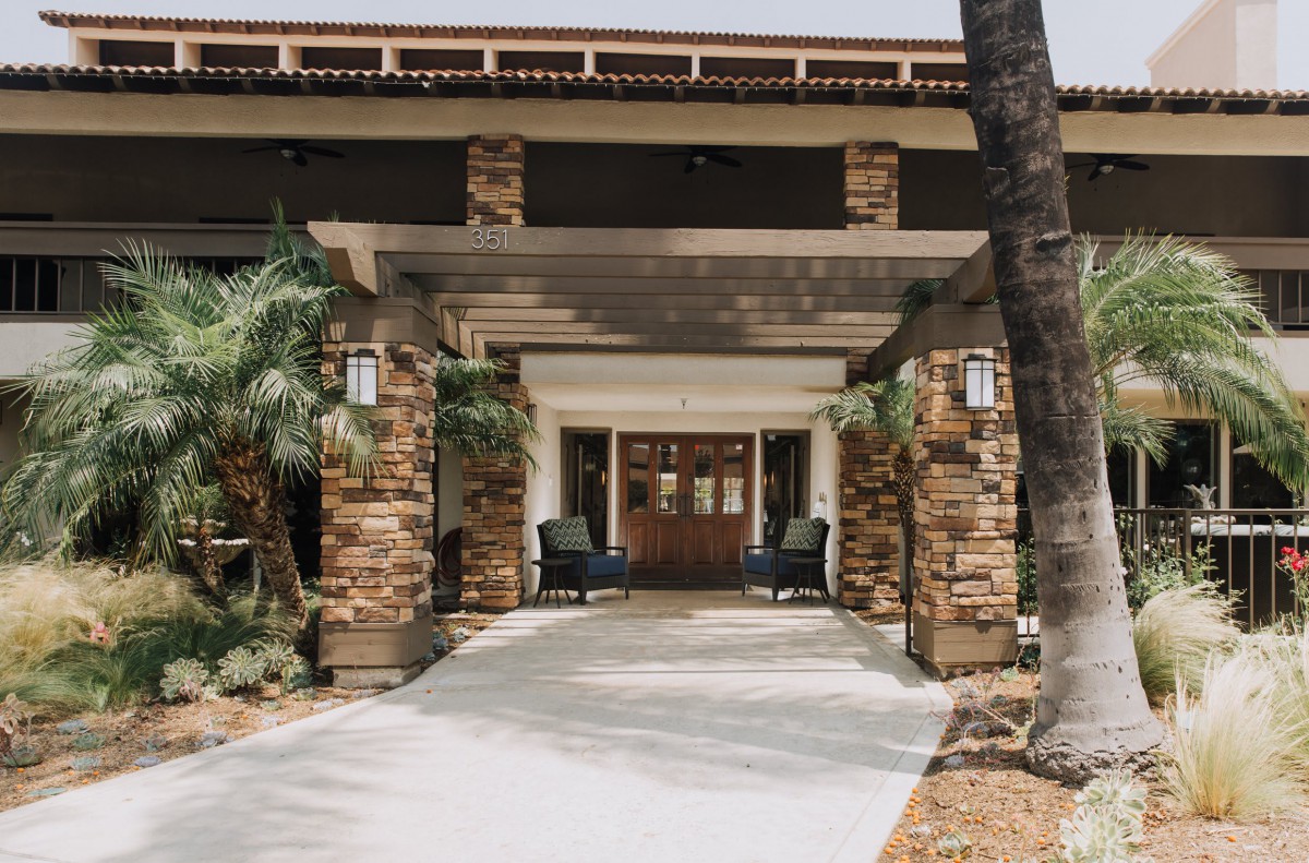 A welcoming entrance with stone pillars and outdoor seating area.
