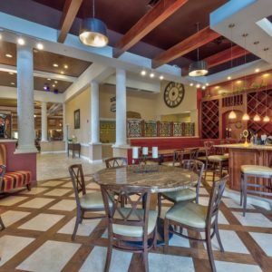 A stylish restaurant interior with a dining area and bar, featuring elegant lighting and decor.