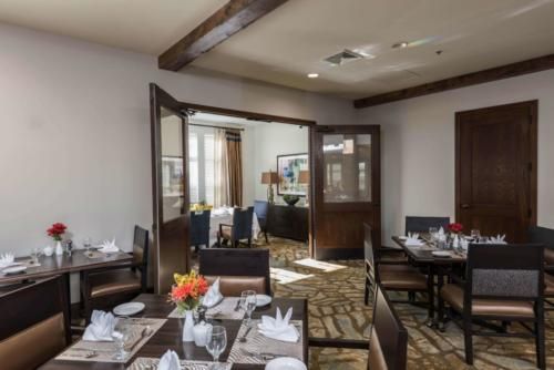 A cozy and elegantly decorated dining room with set tables and chairs.