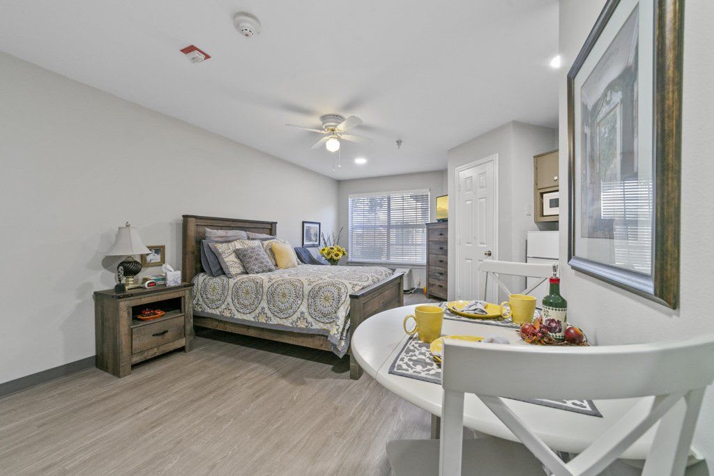 A modern and cozy bedroom with stylish decor, featuring a bed and a small dining table.