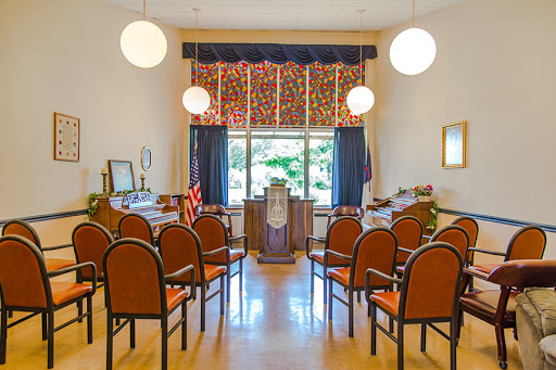 A serene interior setting designed for gatherings or ceremonies, featuring seating and decorative elements.