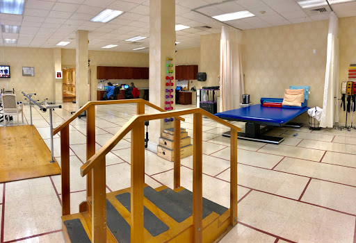 A spacious physical therapy room equipped with a ramp and therapy table for rehabilitation exercises.