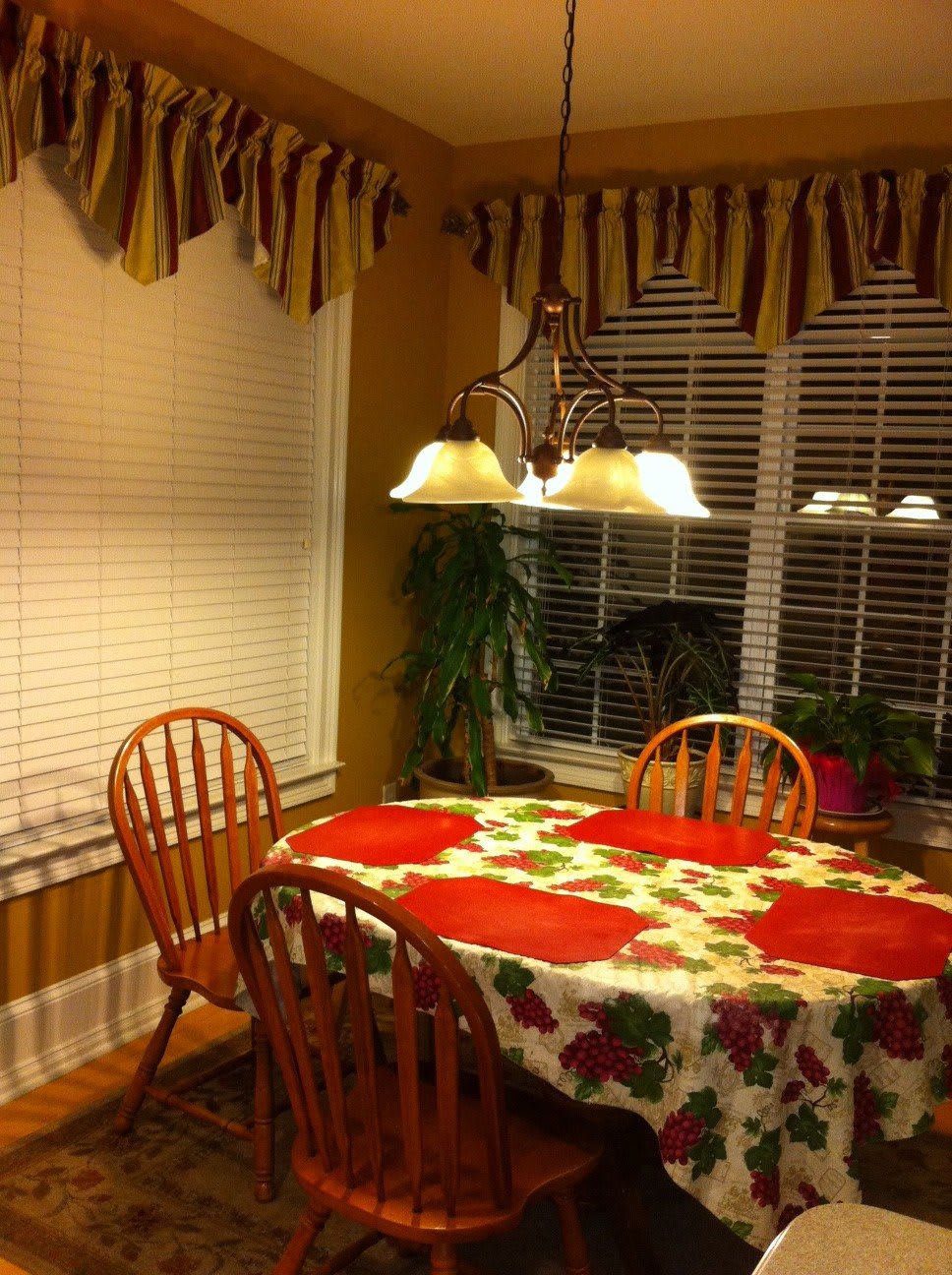 Cozy kitchen dining area with a floral tablecloth and warm lighting.