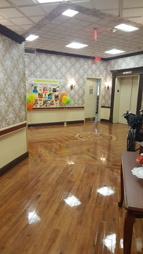 A well-decorated hallway featuring wooden floors and colorful balloons, leading to elevators.