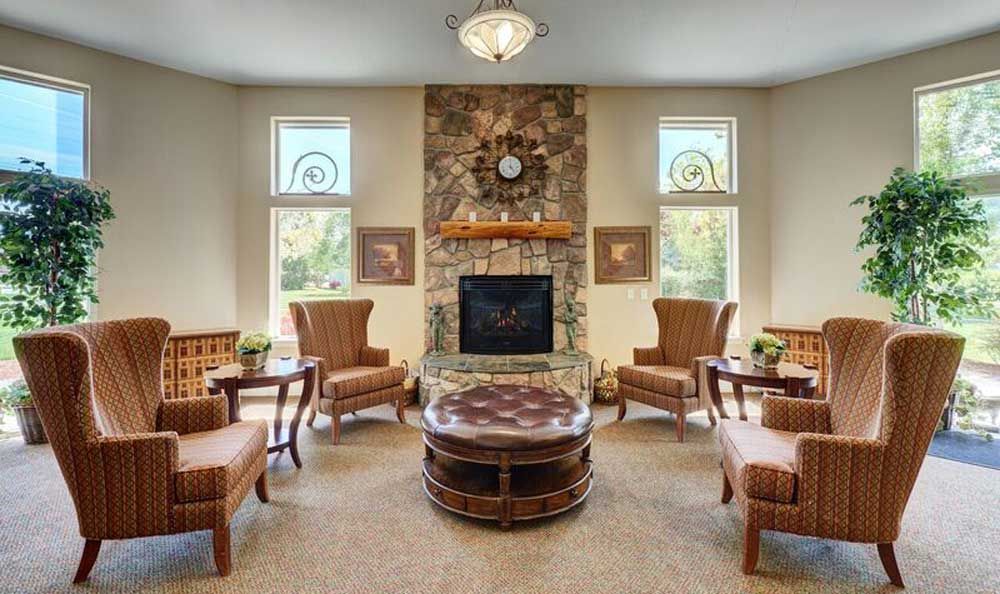 A cozy living room with a stone fireplace and comfortable seating area.