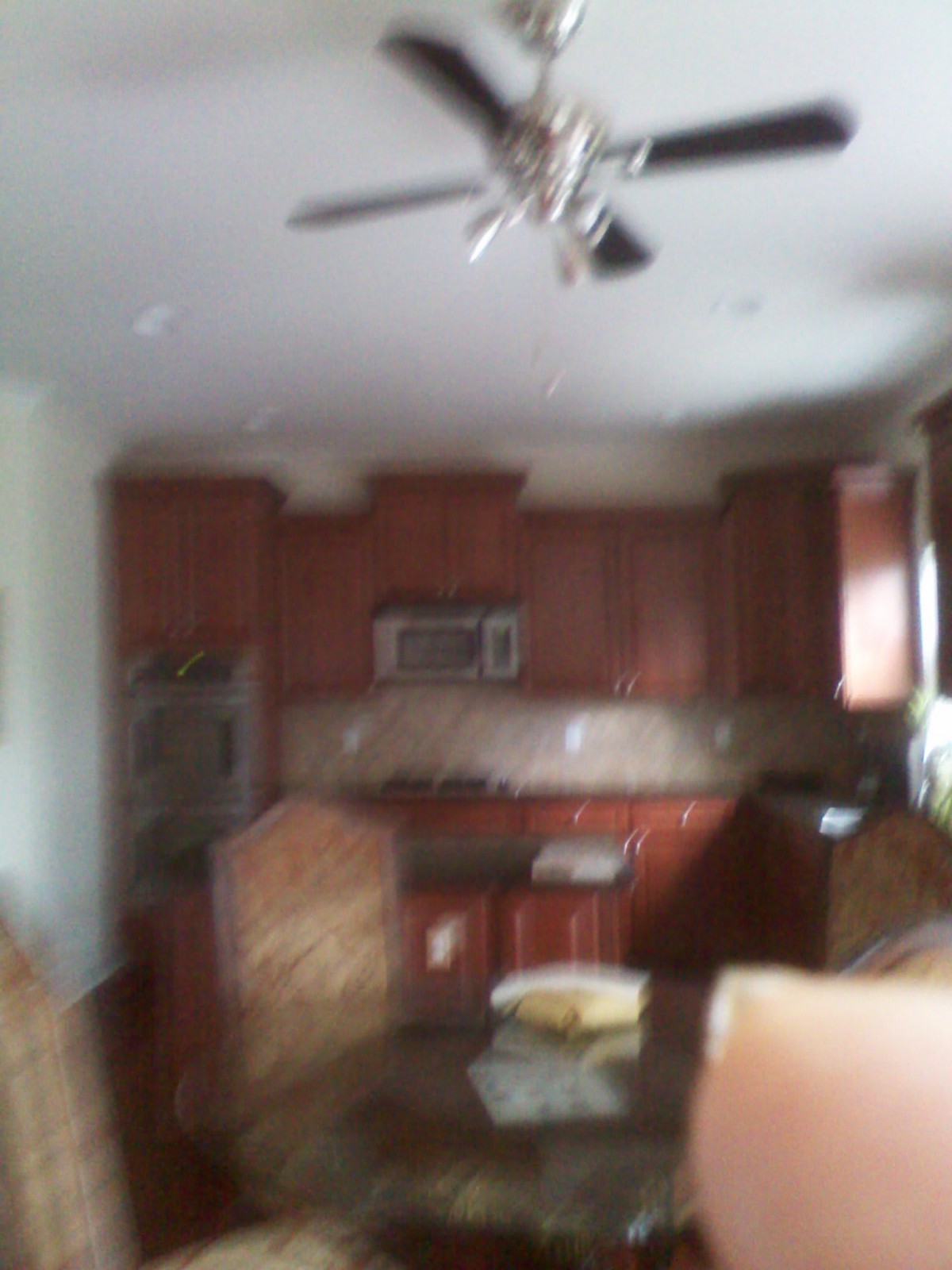 Blurred image of a kitchen with wooden cabinets and dining area.