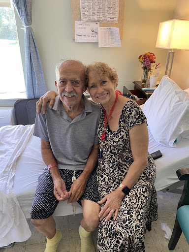 A heartwarming moment shared between a caregiver and an elderly man in a hospital setting.