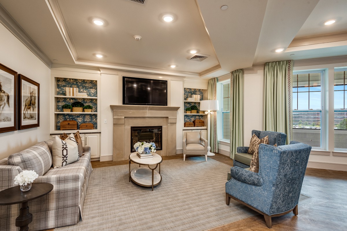 A cozy living room featuring a fireplace, comfortable seating, and built-in bookshelves.