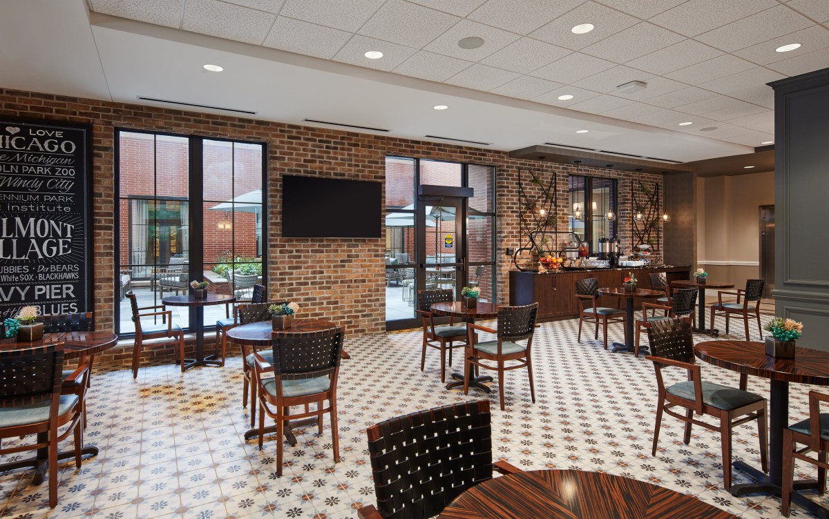 A modern cafe interior with brick walls, tables, and chairs.