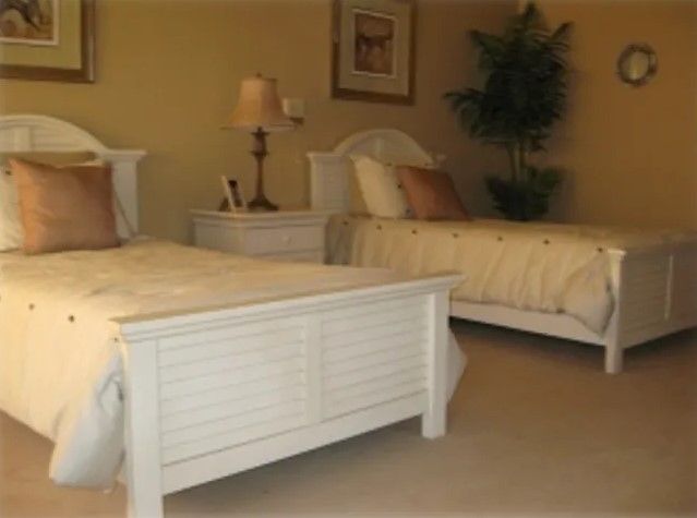 A cozy bedroom with two twin beds and neutral decor.
