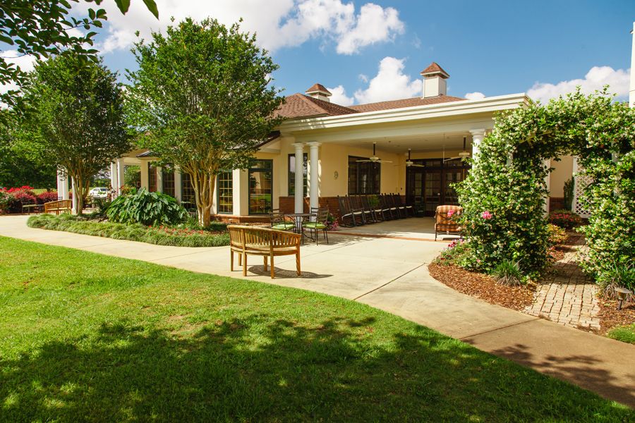 A charming house with a well-maintained garden and patio area.
