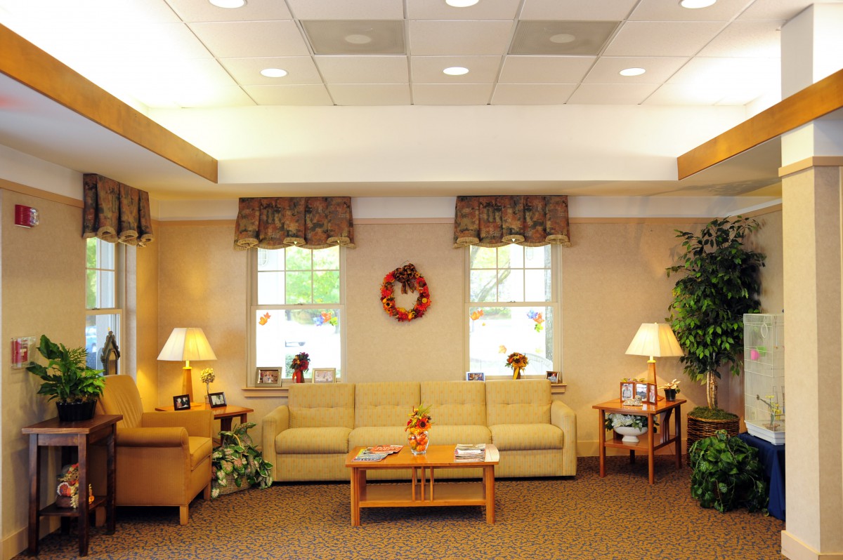 A cozy waiting room with comfortable sofas, warm lighting, and decorative elements.
